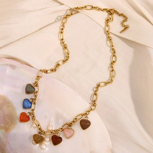 Detail of 18K gold plated chain necklace with colorful heart stones on a silk backdrop
