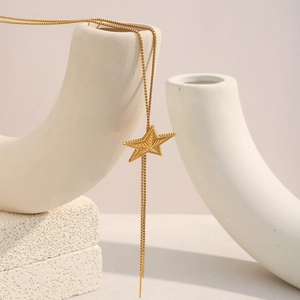 Detail of 18K gold-plated stainless steel star pendant with refined box chain and tassel