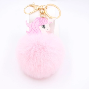 Close-up of pink fluffy unicorn keychain with golden metal clasp and soft plush texture