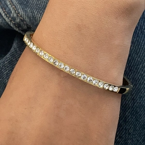 Elegant gold-tone stainless steel rhinestone bangle bracelet on female wrist