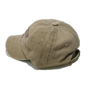 Dettaglio del cappellino da baseball in cotone lavato kaki con tesa usurata e fibbia in metallo