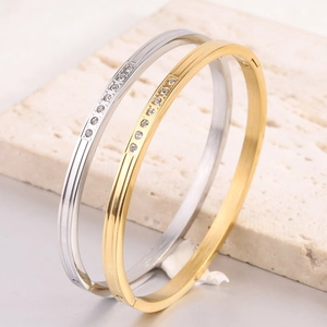 Detail shot of 18K gold and silver stainless steel bangles with row-set zircon crystals