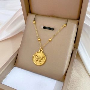 Minimalist gold butterfly pendant necklace displayed on a luxury jewelry box