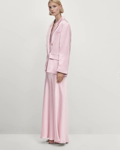 Detail of pink satin blazer and skirt set showing smooth glossy fabric texture