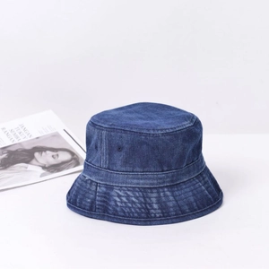 Chapeau bob en denim délavé vintage bleu foncé sur fond blanc avec un magazine de mode