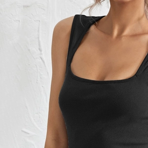 Close-up of black ribbed knit fabric showing detailed texture on a slim fit tank top