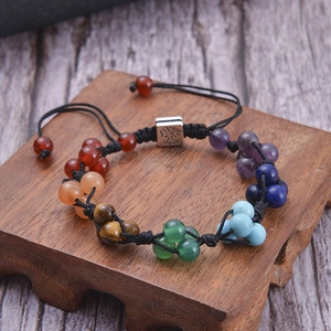 Macro shot of 7 chakra stones woven bracelet featuring a silver Tree of Life charm