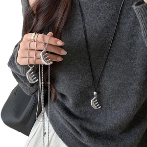 Minimalist leather comb pendant necklace with silver chain on a grey sweater