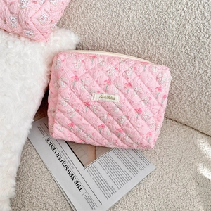 Close-up of pink quilted makeup bag featuring cute rabbit and floral patterns