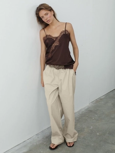 Women's chic lace trim silk camisole and beige wide leg trousers in a minimalist outfit