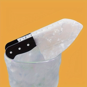 Detailed view of creative knife-shaped ice cube with black handle in a glass cup