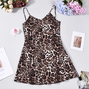 Close-up of leopard print mini dress with thin straps and V-neck on flat lay background