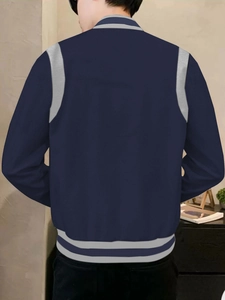 Back view of a navy blue and grey varsity jacket showing the contrasting shoulder panels