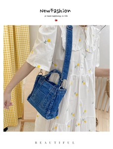 Detail view of retro blue denim crossbody bag with adjustable wide strap and metal hooks