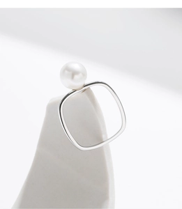 Detail of a square geometric S925 silver ring featuring a white lustrous round pearl