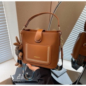 Brown leather bucket bag with retro wide strap and cute bunny plush charm detail