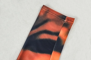 Detail of tiger print jumpsuit showing double-stitched hem and orange gradient fabric texture