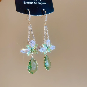 Detail of drop earring with green teardrop crystal and marquise flower design