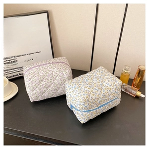 Close-up of quilted floral cotton makeup bags in purple and blue with zipper closure