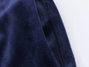 Detail of the pocket opening and soft velvet texture on a dark blue fashion blazer