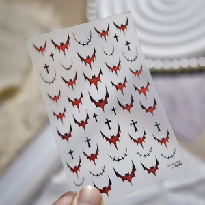 Detail of gothic dark style nail stickers featuring red bats, crosses and thorns