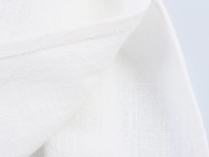 Gros plan sur la texture du tissu en coton blanc avec couture précise sur le costume