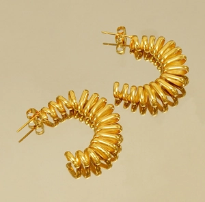 Macro detail of 18k gold plated stainless steel spiral C-shaped hoop earrings