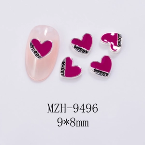 Macro shot of silver heart nail charms featuring sweet lettering in rose red and silver