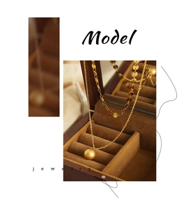 Detail of 18k gold double-layer necklace with matte ball pendant and sequin chain in a box