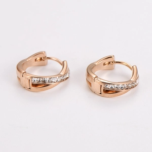 Detail of rose gold huggie earrings with crisscross pattern and clear zircon stones