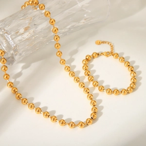 Elegant 18K gold-plated bead chain necklace and bracelet set on a neutral background