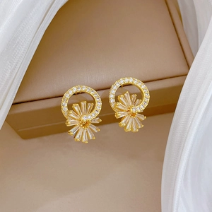 Luxurious flower stud earrings in gold with cubic zirconia crystals on jewelry box