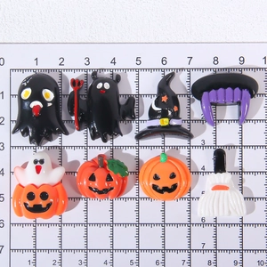 Detailed view of Halloween resin charms set on a metric scale mat showing various sizes