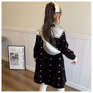 Silver quilted crossbody bag worn by a child with a black floral velvet dress