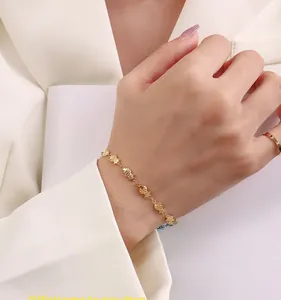 Close-up of minimalist gold fish tail bracelet with detailed texture and matching ring