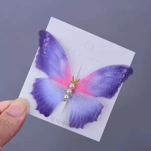 Close-up of ethereal tulle butterfly hair clip with pearls and gradient purple texture
