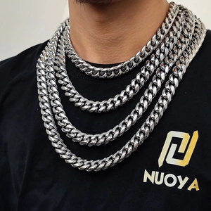 Polished silver cuban link chains in various lengths layered on a black t-shirt