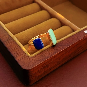 Detail of vintage French gold ring with navy and green rectangular enamel in a jewelry box