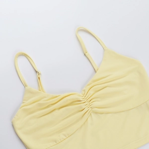 Detail of light yellow camisole showing central ruched texture and adjustable straps