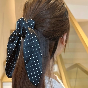 Elegant black silk hair scrunchie with white polka dots and a bow tie ribbon design