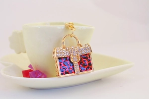 Detail of leopard print purse keychain with rhinestones hanging on a coffee cup