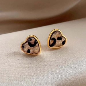 Detail of heart-shaped earrings with gold plating and vintage leopard print texture