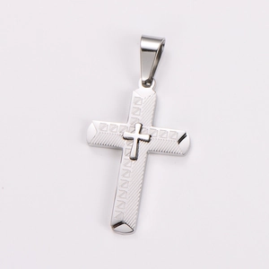 Macro shot of silver stainless steel cross pendant with textured geometric engraving