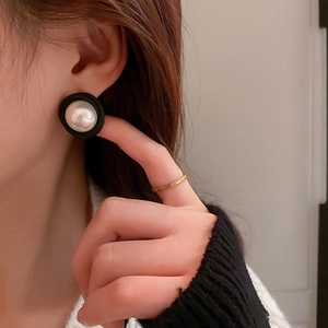 Boucles d'oreilles rondes en acrylique rétro avec perle blanche portées par un mannequin