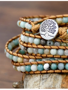 Close-up of bohemian multi-layer beaded bracelet with tree of life silver button clasp