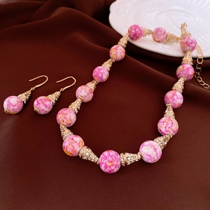 Dettaglio di set gioielli vintage con perle di marmo rosa e strass su velluto