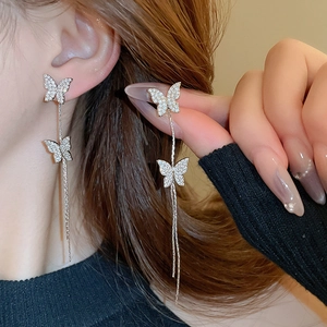 Detail of silver long tassel butterfly earrings with sparkling crystals on female model