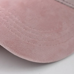 Detailopname van de roze chenille honkbalpet met precieze parallelle stiksels