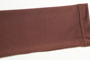 Gros plan sur tissu en maille élastique marron foncé avec coutures à double aiguille