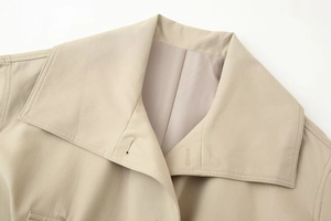 Close-up of khaki trench coat collar featuring refined stitching and twill fabric texture